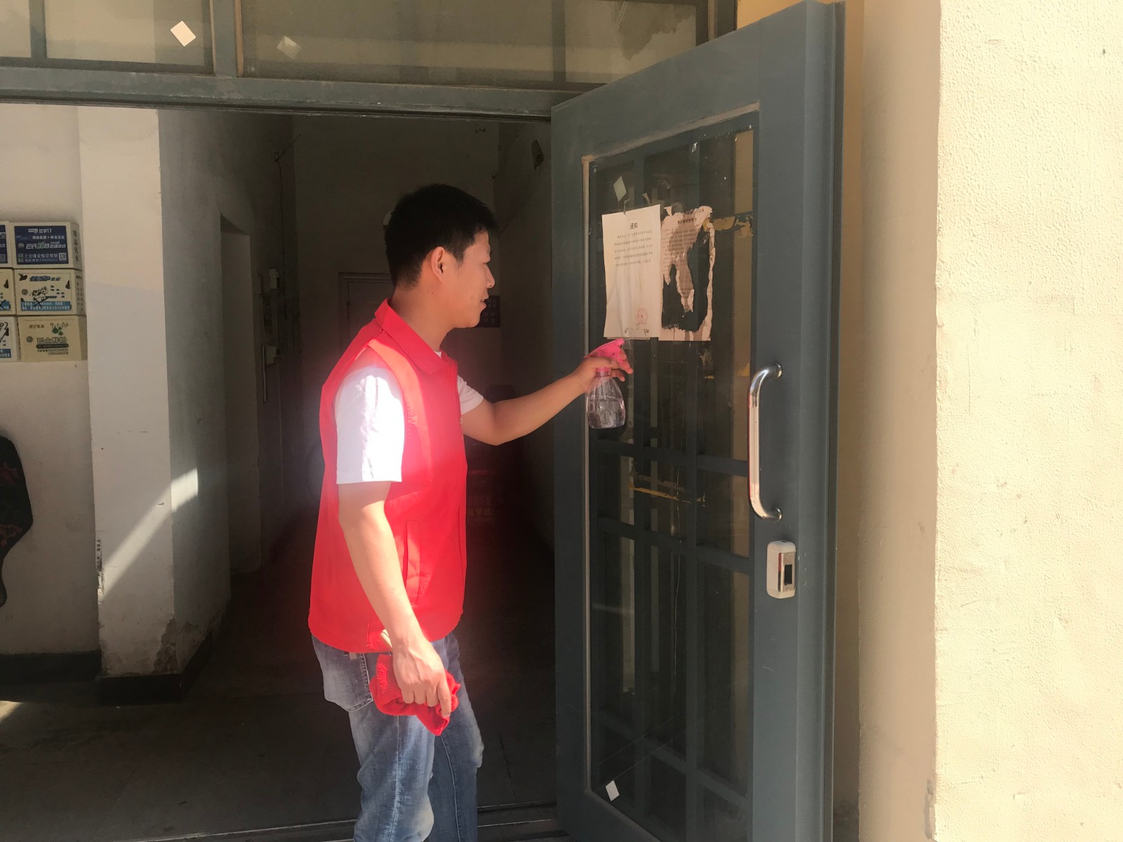 正阳社区新时代文明实践志愿者刘国顺在馨宁小区清理单元门口的小广告（摄影：郝德华）