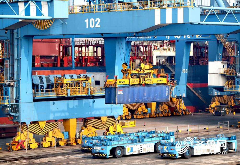 1月6日，在山东港口青岛港全自动化码头，一艘货轮在装载货物。（张进刚