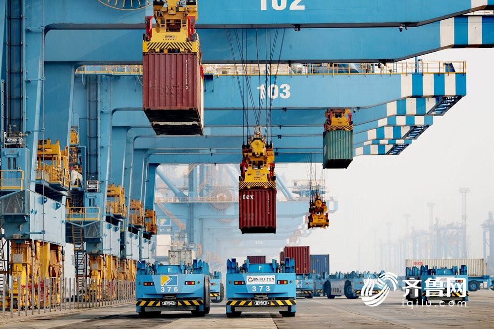 1月6日，在山东港口青岛港全自动化码头，自动导引车在码头上快速运送货物。（张进刚
