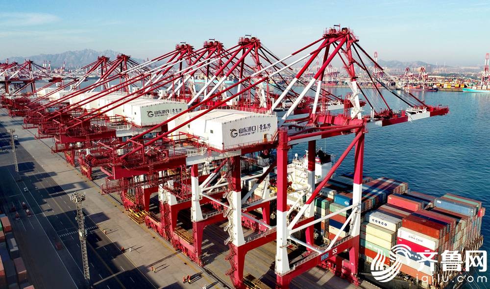 1月14日，在山东港口青岛港前湾集装箱码头，一艘货轮在装载货物。（张进刚