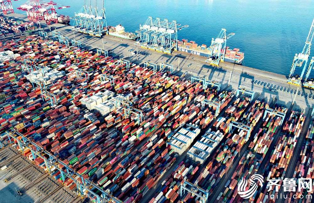 1月14日，在山东港口青岛港全自动化码头，数艘货轮靠泊在码头装卸货物。（张进刚
