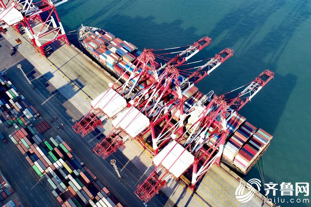 1月14日，在山东港口青岛港前湾集装箱码头，一艘货轮在装载货物。（张进刚