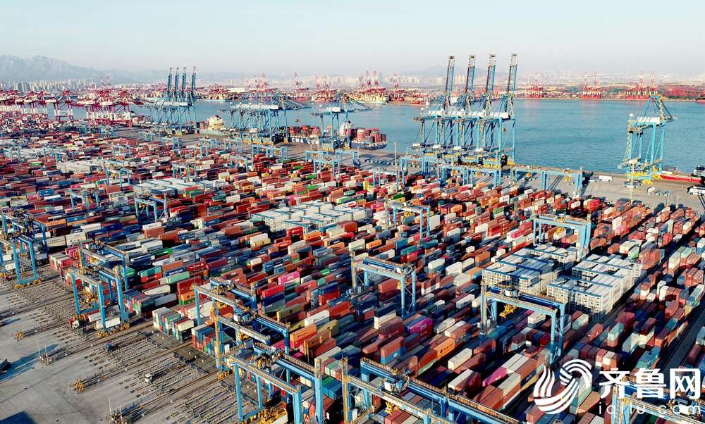 1月14日，在山东港口青岛港全自动化码头，集装箱堆场一派繁忙，数艘货轮靠泊在岸边装卸货物。（张进刚