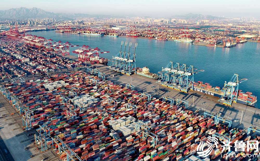 1月14日，在山东港口青岛港全自动化码头，集装箱堆场一派繁忙，数艘货轮靠泊在岸边装卸货物。（张进刚