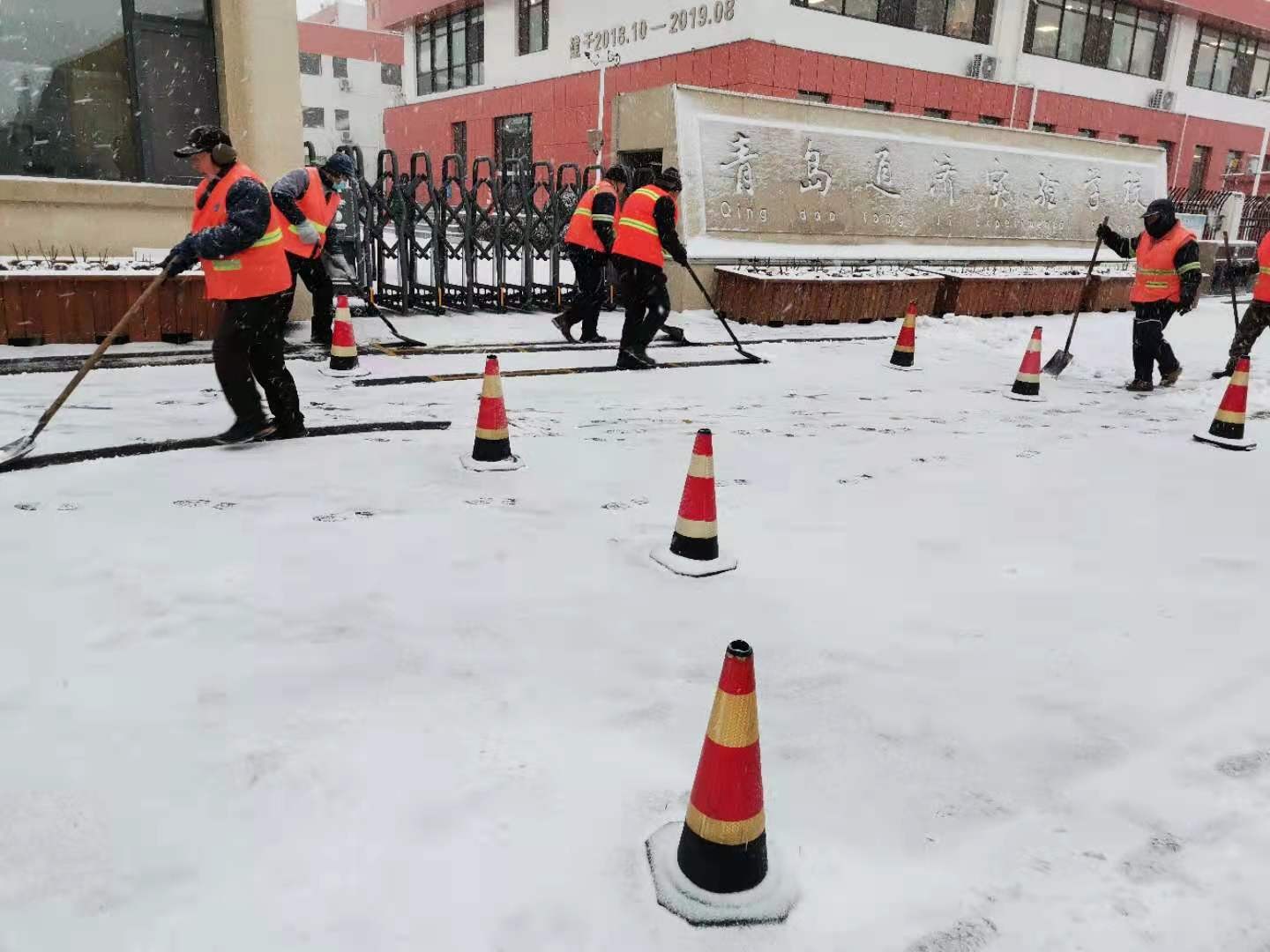 通济新经济区组织环卫办工作人员在通济实验学校撒融雪剂，清理积雪路面，切实保障学生们的出行安全。