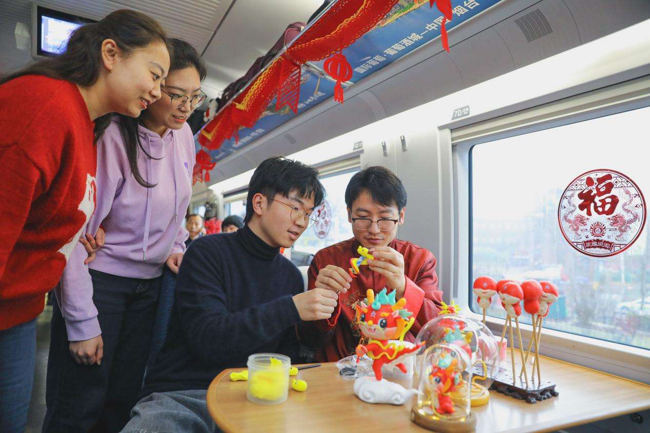 2024年1月31日，旅客在青岛开往北京的G1068次列车上体验非遗项目。张鹰 摄 (2)
