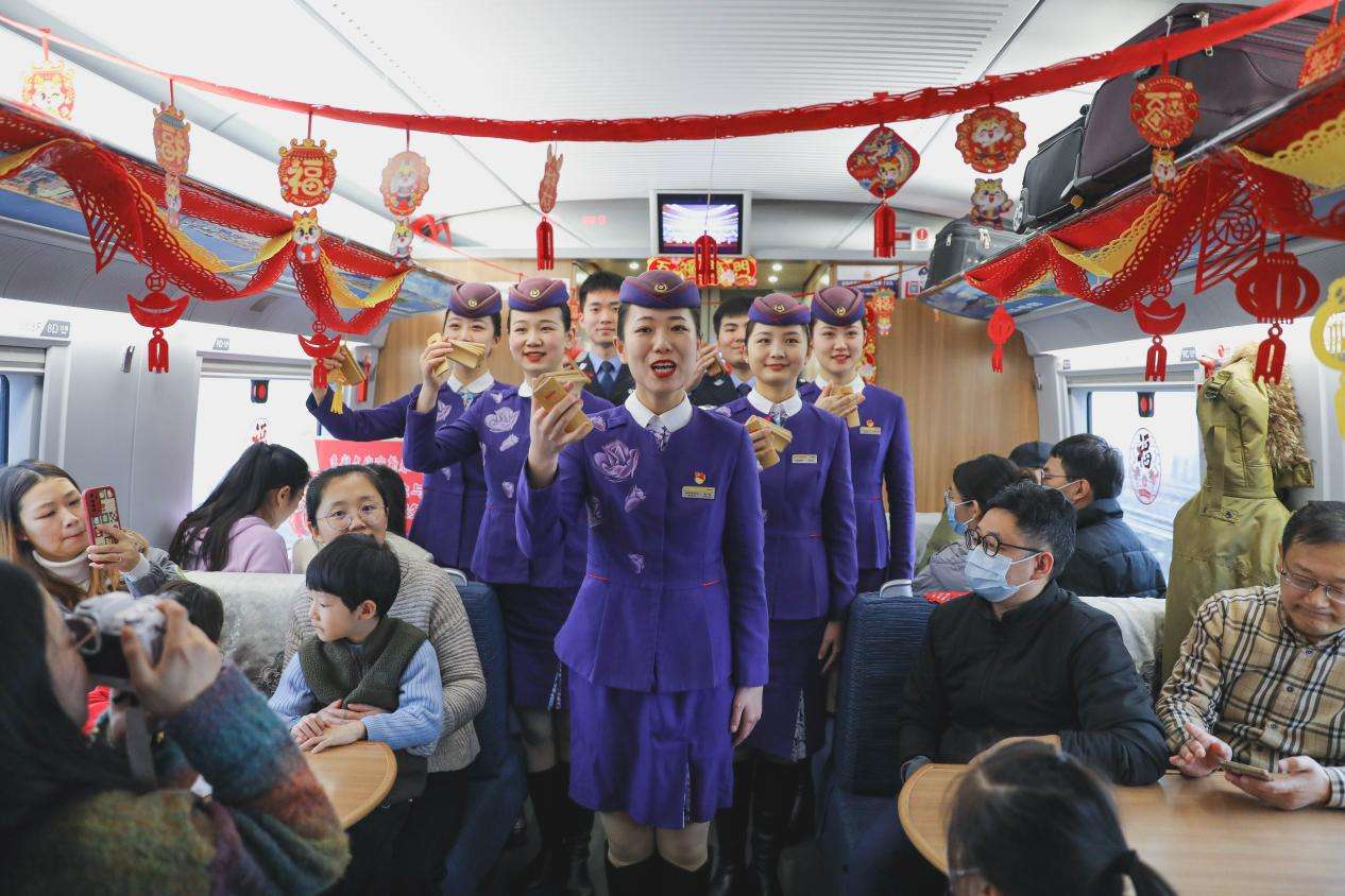 2024年1月31日，乘务人员在青岛开往北京的G1068次列车上为旅客表演快板。张鹰 摄