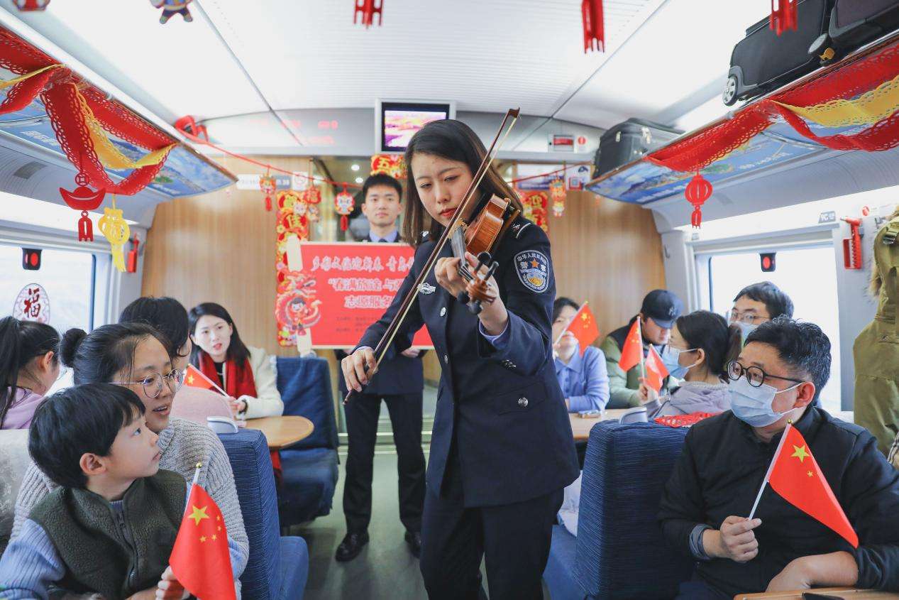 2024年1月31日，民警在青岛开往北京的G1068次列车上为旅客演奏小提琴。张鹰 摄