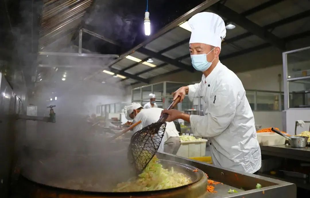 图为 王正华在炒菜.jpg