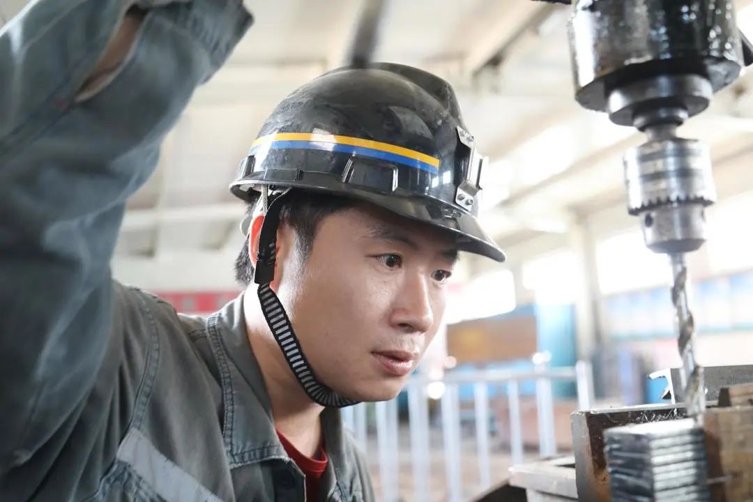 专注的眼神,七五煤业公司综合车间职工秦雷正在聚精会神进行接地极连板孔定位打卡,他的眼神彰显着煤矿职工