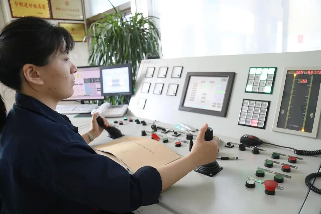 七五煤业公司副井绞车房绞车司机安冉,手握主令操作柄、自动手柄,全神贯注进行精准操作,确保提升系统运输