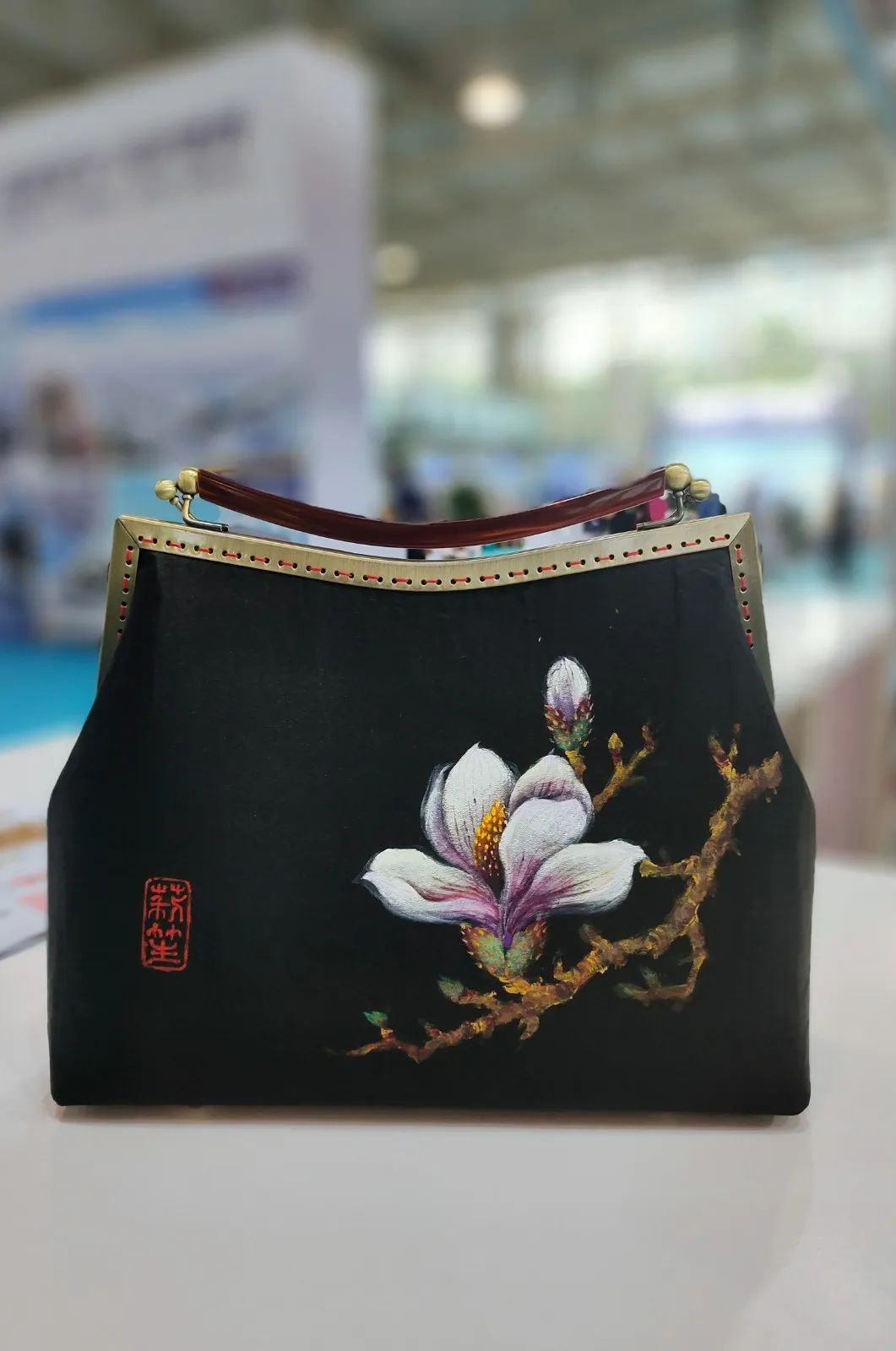 上图中香云纱手工包出自潍坊市工艺美术大师马玉芳之手.